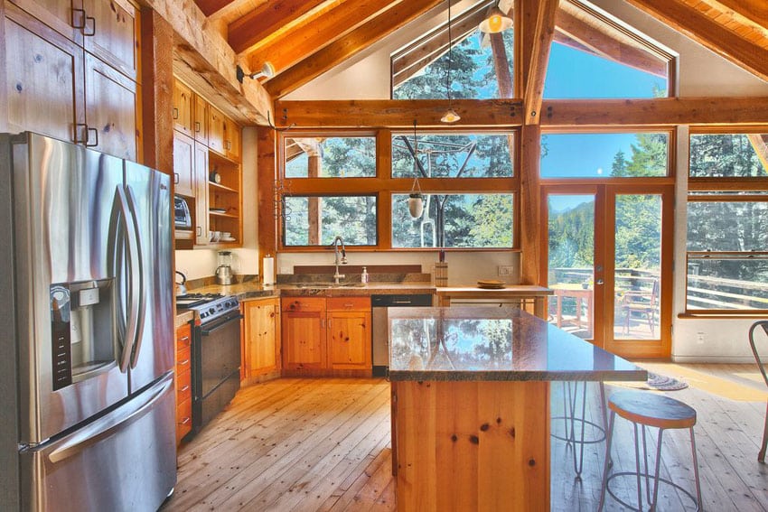 Kitchen with large windows, exposed rafters and cabinets with hickory