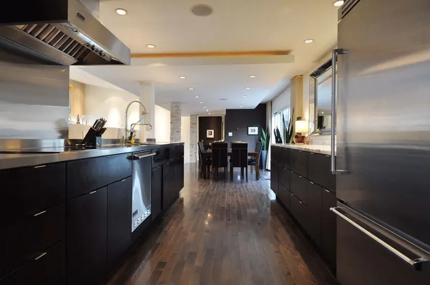 Galley style kitchen with black wood strip flooring