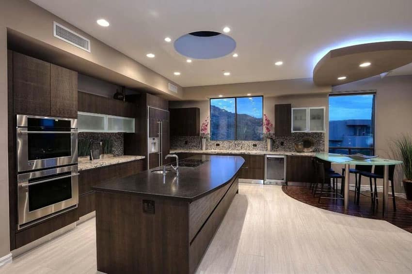 Kitchen with built-in oven, curved countertop and pine wood floors