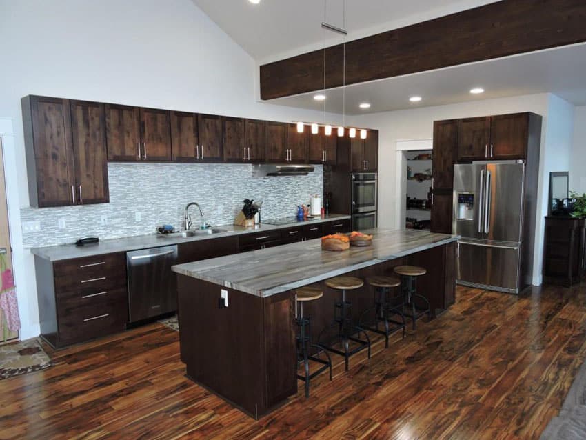 Contemporary kitchen with dark wood cabinets, marble counter, mazama wood floors and dining island