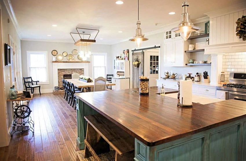 Country kitchen with green distressed wood island with wood countertop, plank hardwood flooring and ceramic tile backsplash