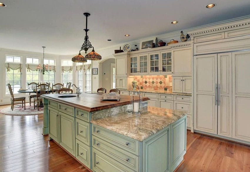 Country kitchen with light green two tier island with butcher block counter and typhoon bordeaux granite