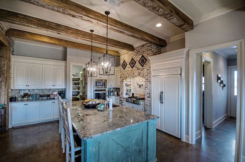 Rustic farmhouse kitchen with white raised panel cabinets and painted green distressed island with blizzard granite counter