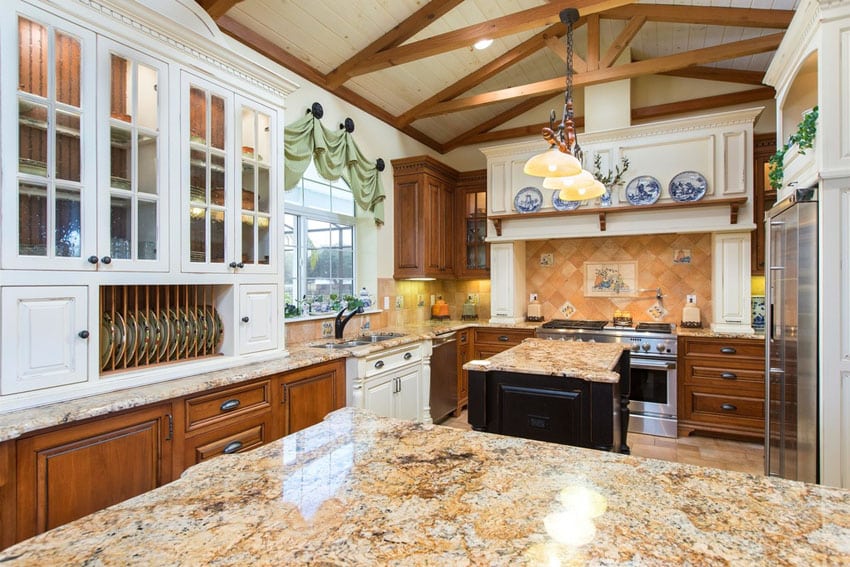 Country style kitchen with rustic white cabinet uppers and brown lower cabinets and beige granite island