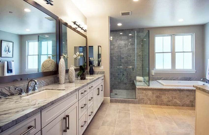 Custom bathroom with travertine floor tile and dual sink marble vanity with white cabinet