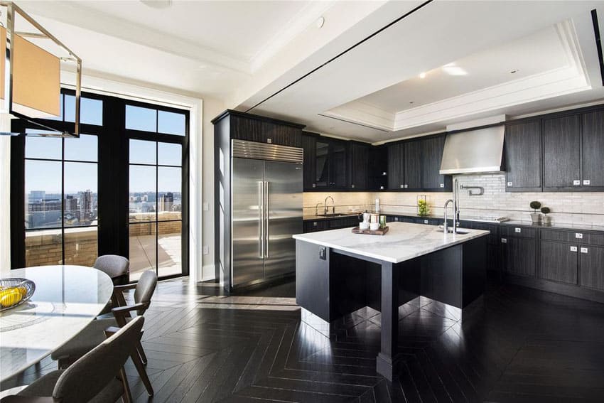 Dark cabinet kitchen with calacatta classic marble counters and white subway tile backsplash