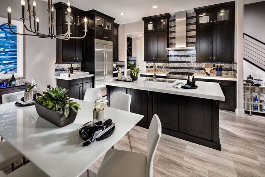 Dark cabinet kitchen with white super thassos glass countertop and light wood floors