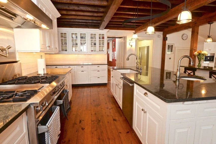 Modern farmhouse kitchen with white cabinets, blue pearl silver granite countertop and wide plank hardwood floors