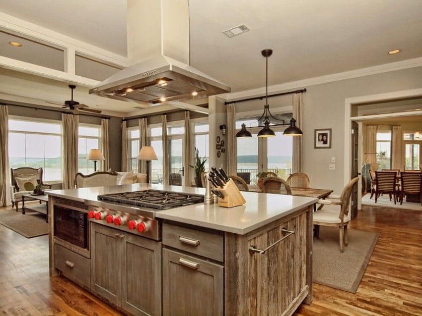 Open layout kitchen with floor to ceiling windows and counters with stove top