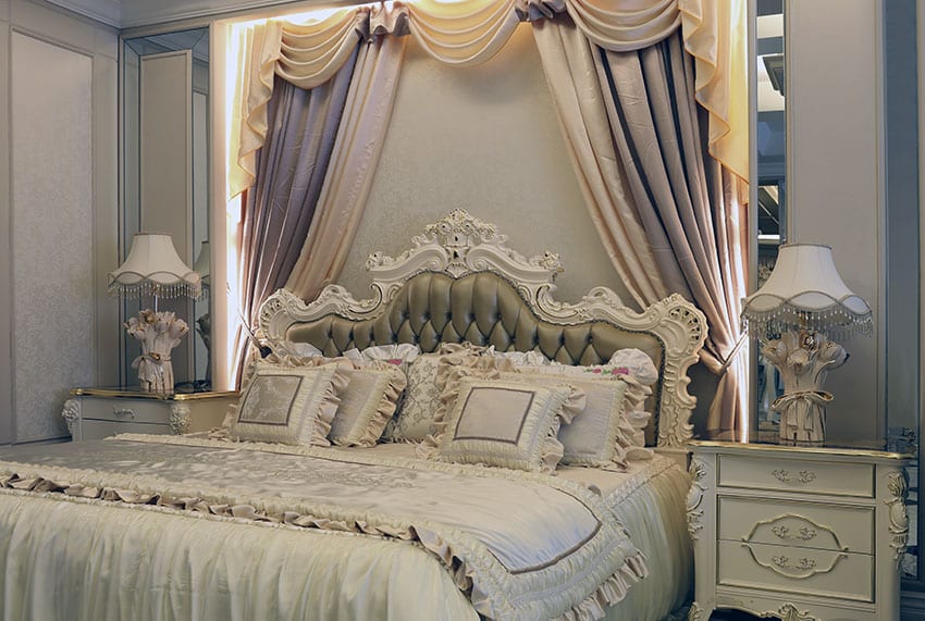 Luxury Parisian style bedroom with antique off white furniture, flowing curtains and tufted bed