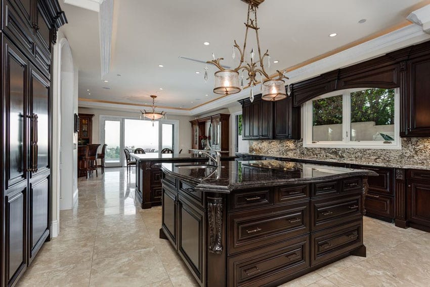 Luxury traditional kitchen with dark raised panel cabinets, emperador dark marble counter island and light granite backsplash