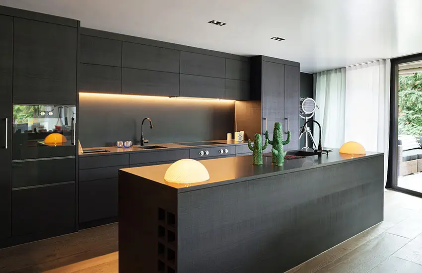 Black cabinetry with warm yellow under cabinet lighting