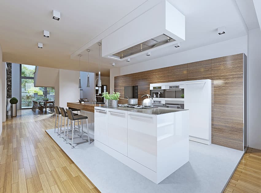 Modern dark wood cabinet one wall kitchen with white island and light wood flooring