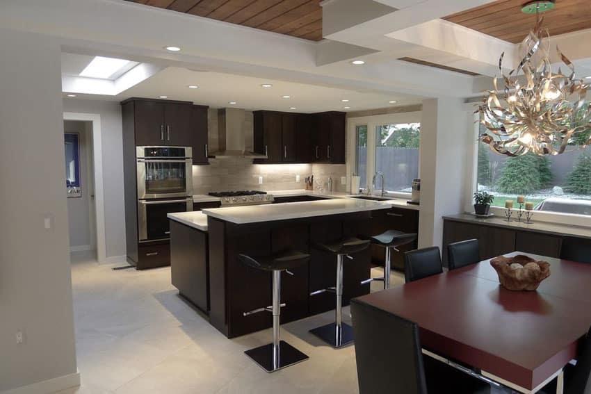 Modern kitchen with dark cabinets, split level light counter breakfast bar and open layout