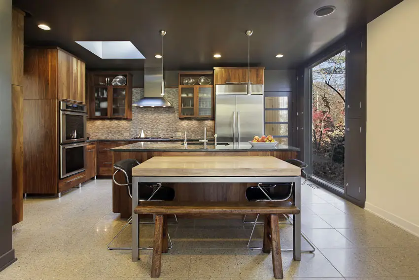 Modern kitchen with wood surface island, granite backsplash and sliding glass door