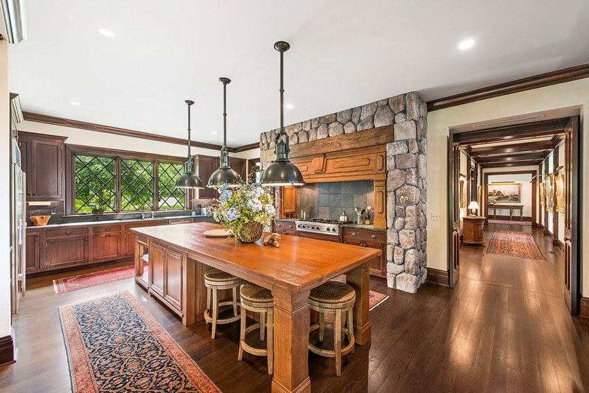 Kitchen with custom stone surround, cherry wood board flooring and oak cabinets