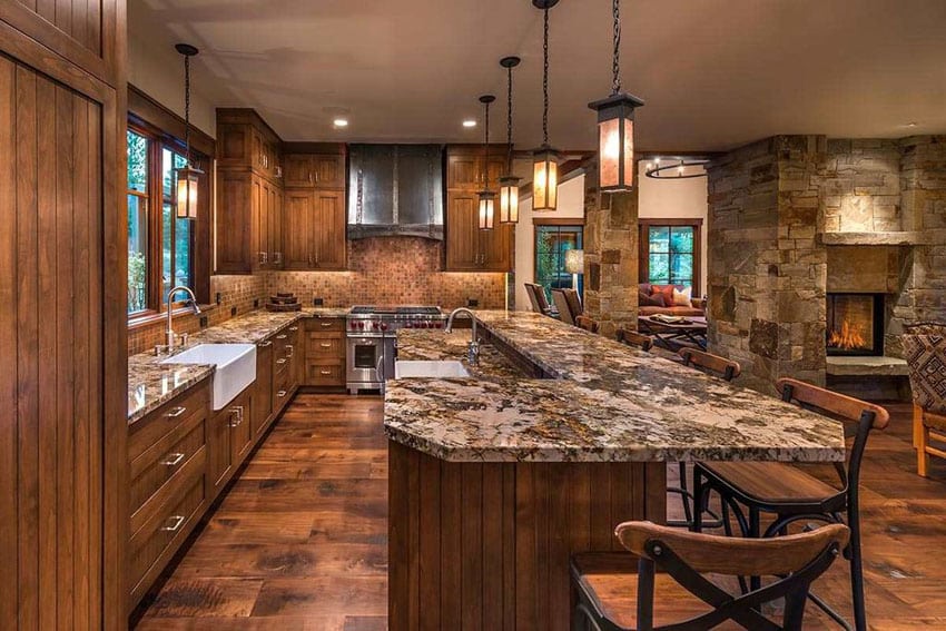 Rustic kitchen with dark granite breakfast bar farmhouse sink and stone fireplace