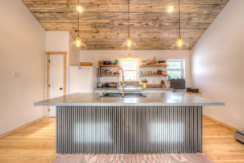 Modern rustic kitchen with slanted ceiling, corrugated side island with concrete counter
