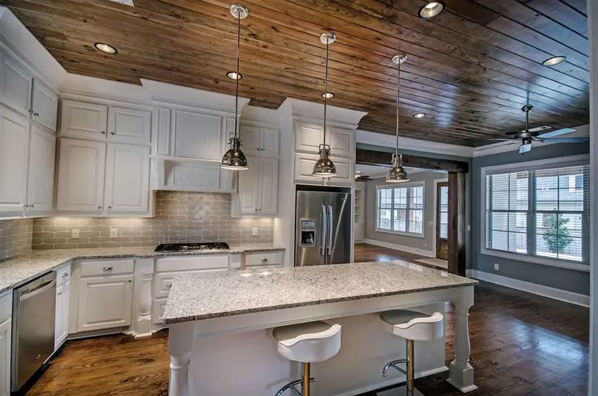 Cabinets in antique white finish, shiplap walls, dome lights and white stools
