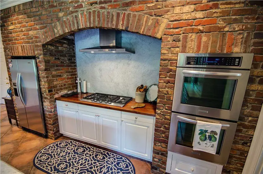 Kitchen with brick surround with curved arch and weathered tiles
