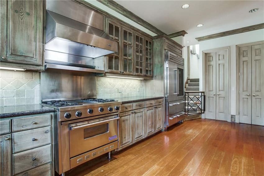 Rustic one wall kitchen with viking range wood floors and limestone backsplash