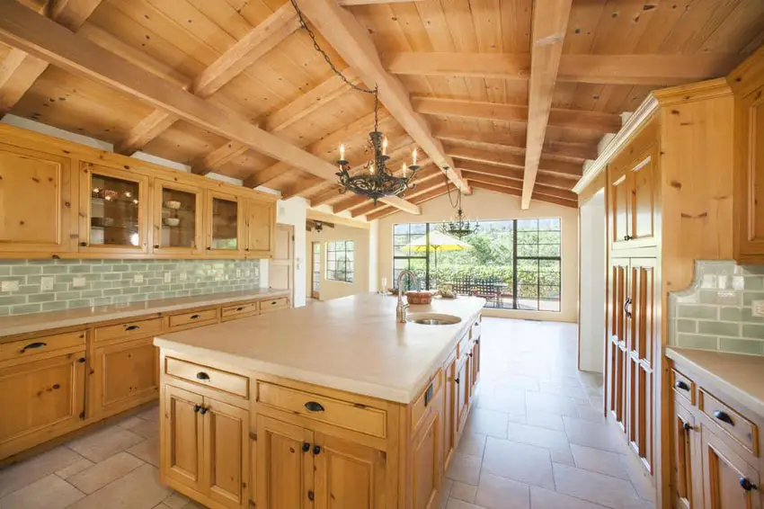 Kitchen with sloped teakwood beams on ceiling with solid surface countertops