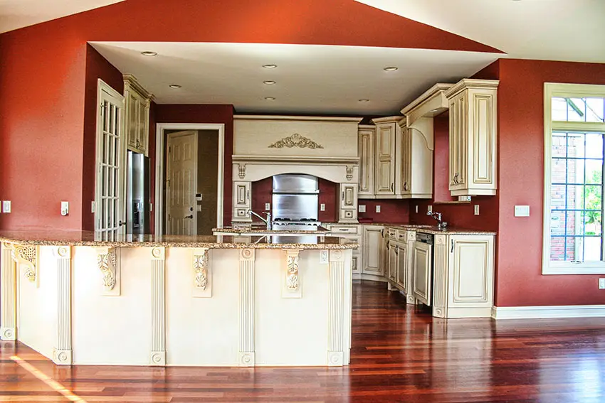 Painted cream color decorative cabinetry, granite peninsula and red walls
