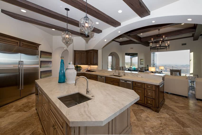 Traditional kitchen with custom designed island with built in sink arched walls and exposed beam ceiling