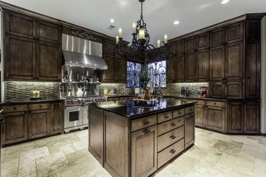 Traditional kitchen with dark wood cabinets, rustic wrought iron chandelier and honed travertine floors