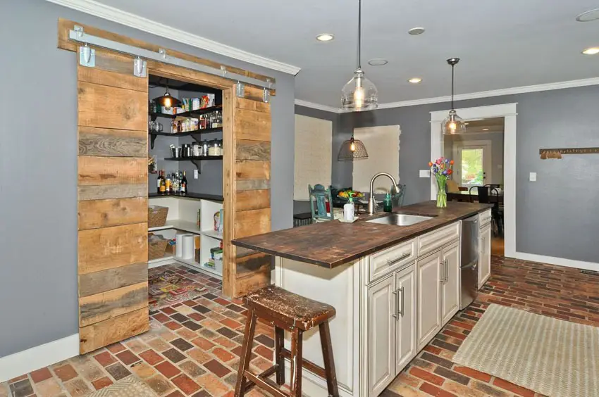 Rustic style kitchen with reclaimed wood counter island, wood floors and beam ceiling