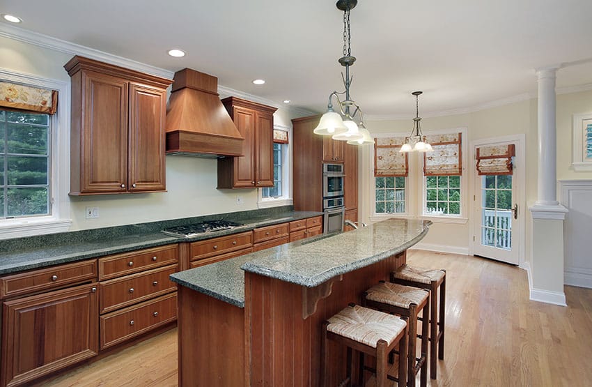 Traditional one wall kitchen with two tier breakfast bar island and backless bar stools