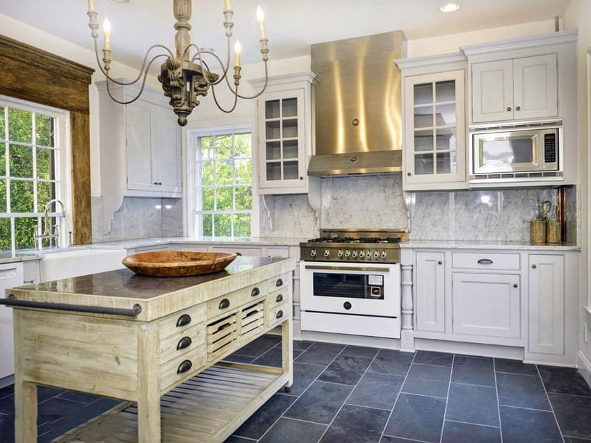 Kitchen with bronze chandelier, mullioned cabinets and blue stone tiles