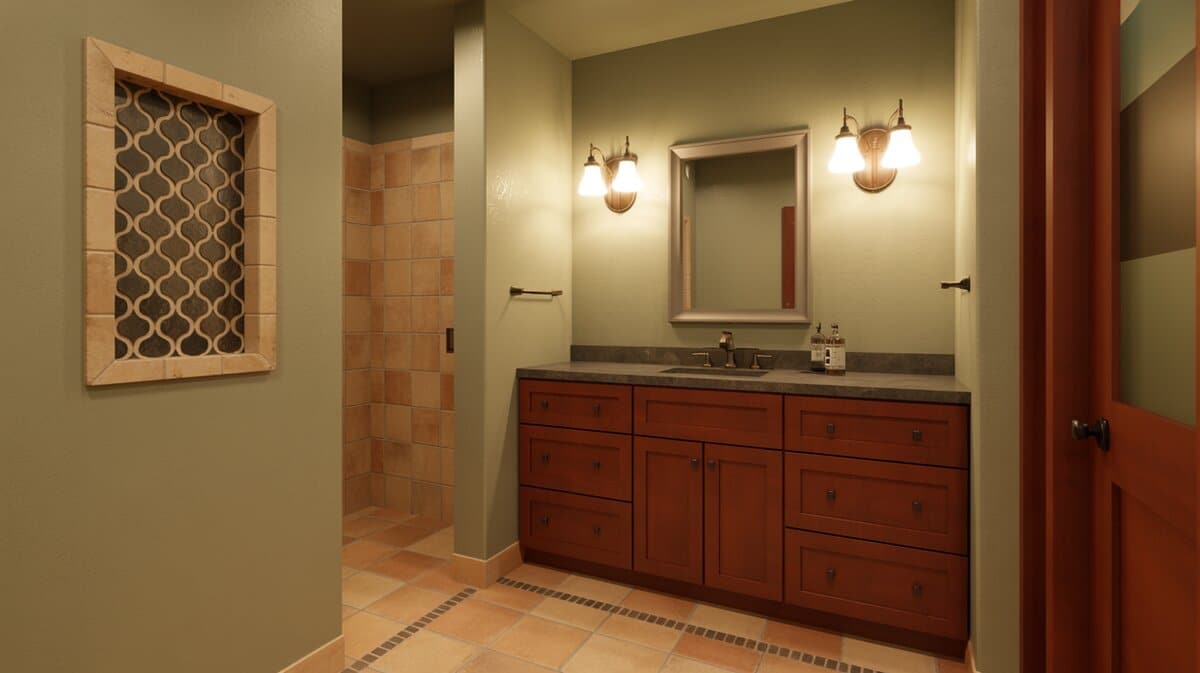 Cherry vanity below sconces with an arabesque tile niche and terracotta floor