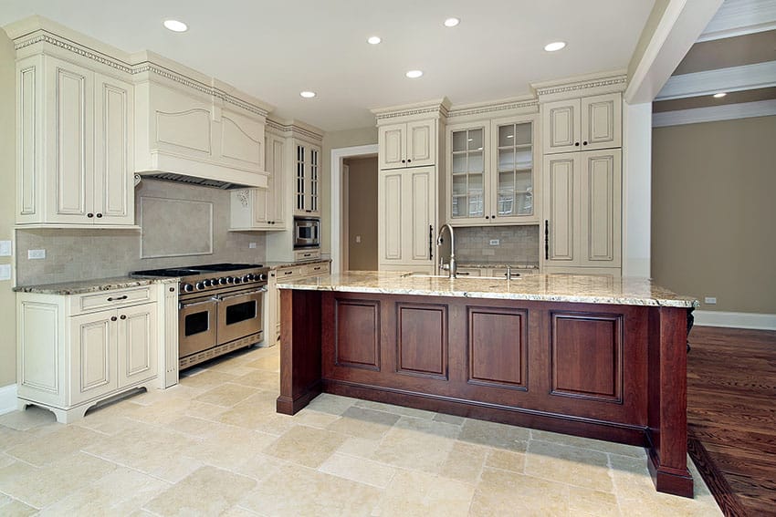 Kitchen with coursed sandstone floor and island with wood plinth