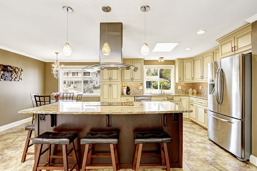 Antique white kitchen cabinets with island and beige granite counter