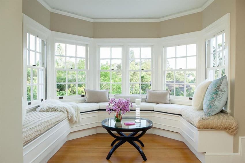 Beautiful bay window seat with comfy cushions and wood table