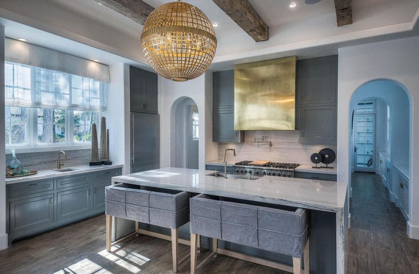 Beautiful contemporary kitchen with dark blue cabinets and calacatta lasa marble, and large gold pendant 