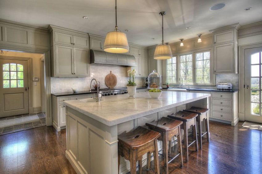 Beautiful cottage kitchen with carrara marble counter and large island with wood flooring