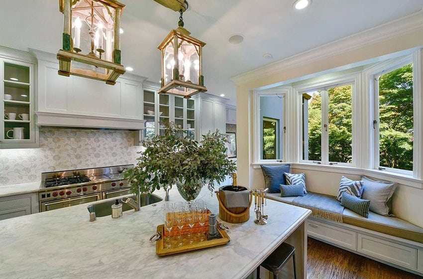 Kitchen with patterned tile backsplash, lamp pendant lights and marble countertop