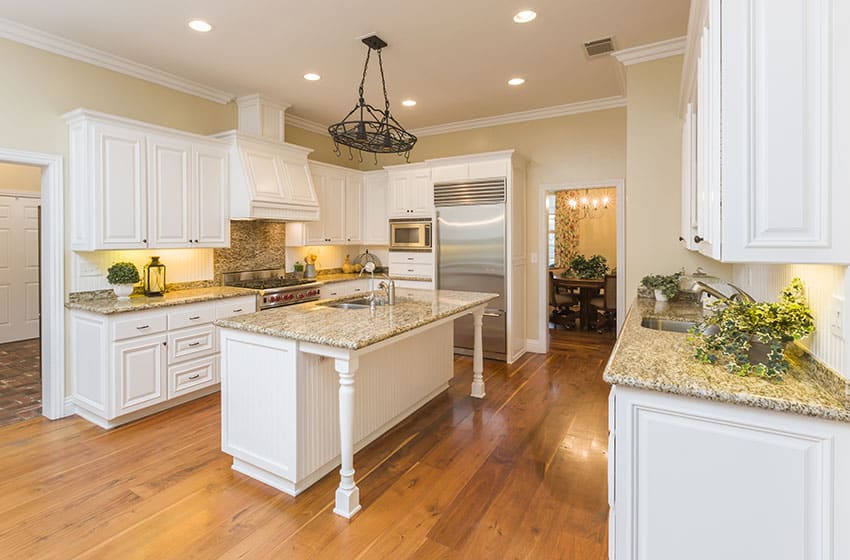 Beautiful white country style kitchen with yellow granite counter and island with sink