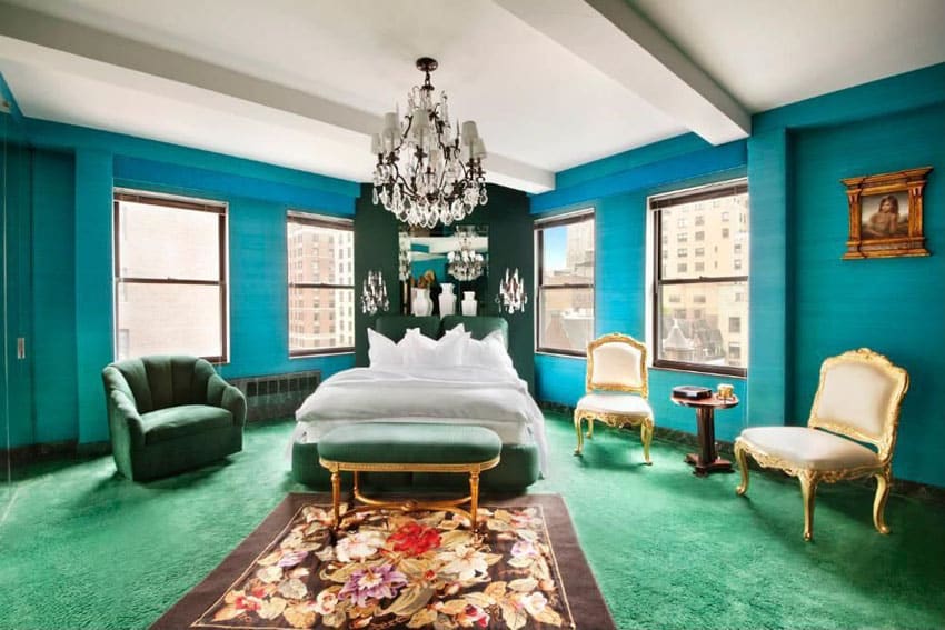 Bedroom with teal painted walls, chandelier and green carpet