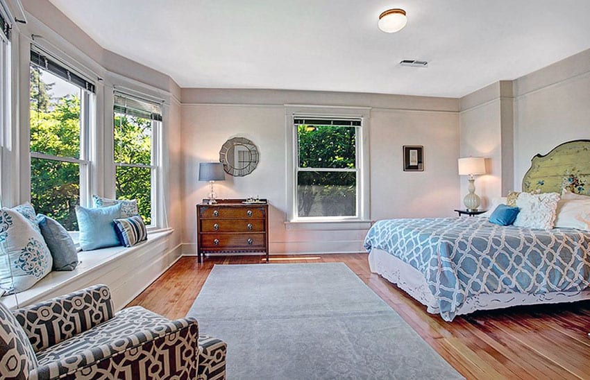 Bedroom with red oak hardwood floors, flush light and wood headboard
