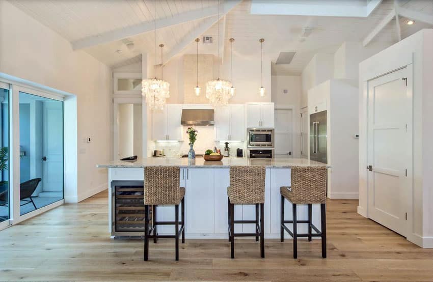 Bright cottage kitchen with white cabinets and light wood flooring
