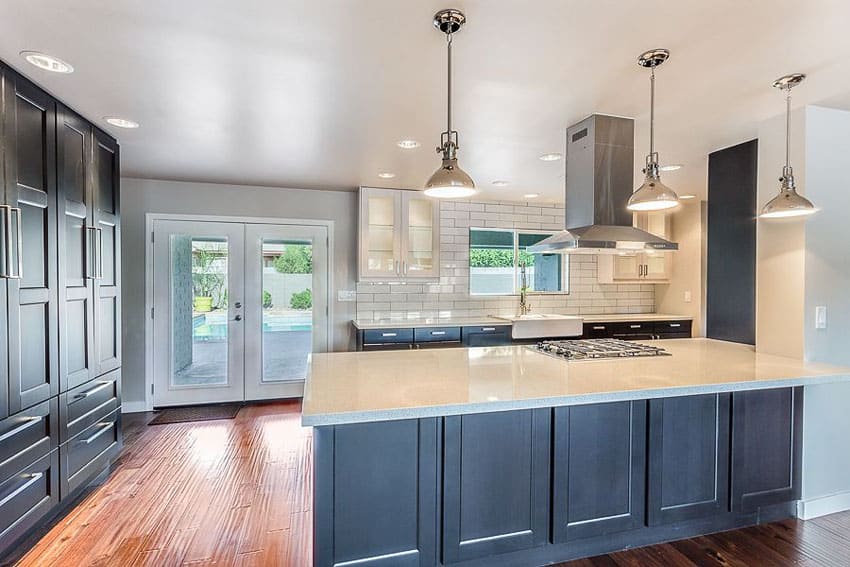 Kitchen with subway tile backsplash, white zeus countertops and chrome pendant lighting fixtures