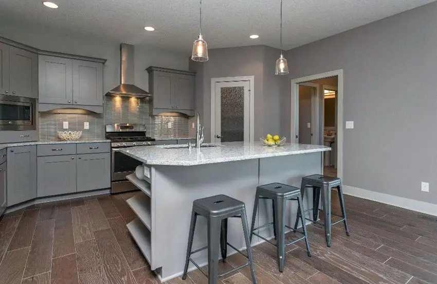 Contemporary kitchen with gray flat panel cabinets, gray backsplash tiles and white granite counter