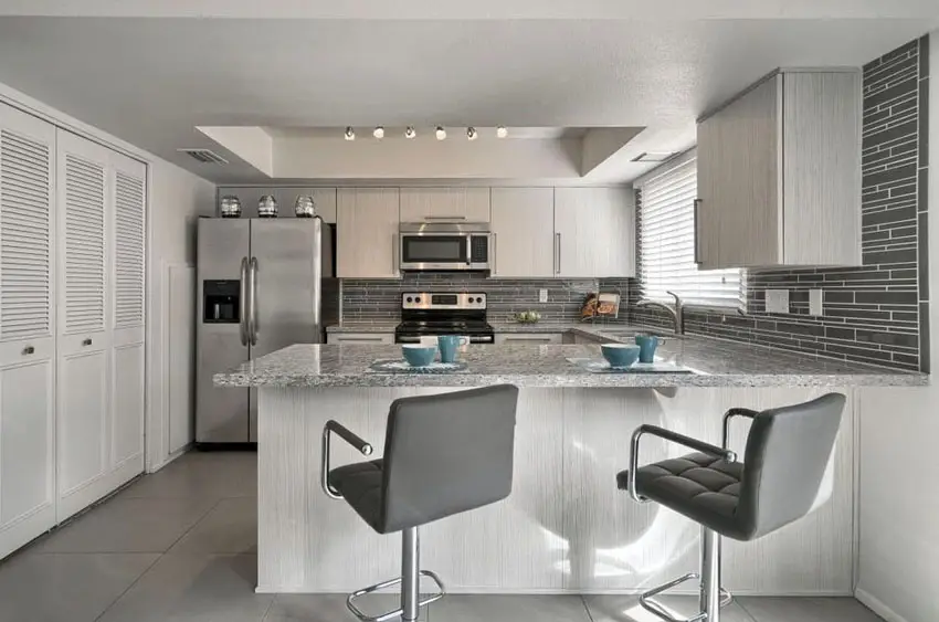 Contemporary kitchen with peninsula, white cabinets and gray mosaic tile backsplash