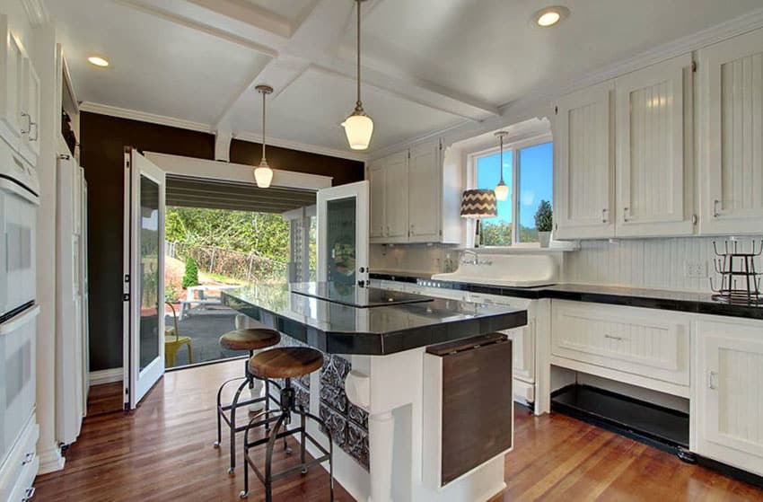 Kitchen with beadboard cabinets wood floors and eat in dining island