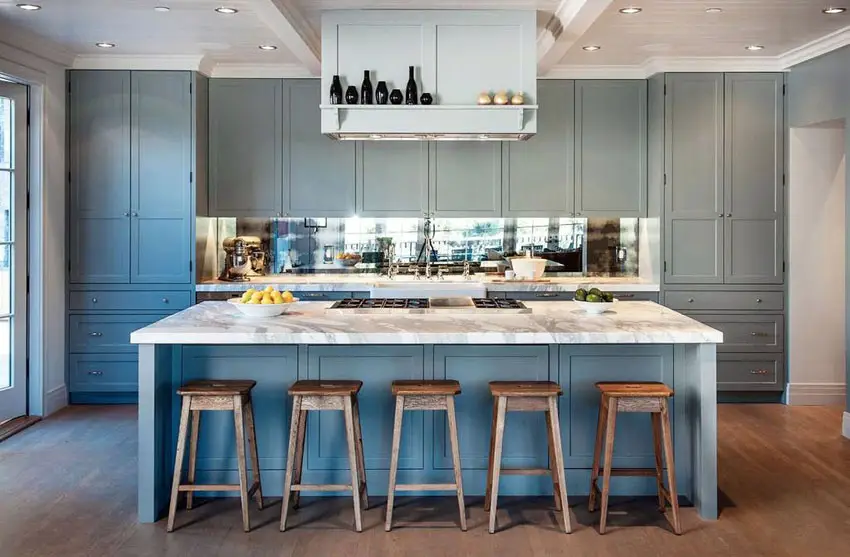 Kitchen with green gray cabinetry, island and flush lighting