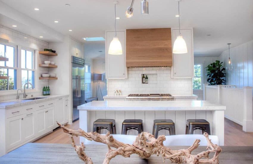 Cottage kitchen with white cabinets white tile backsplash and long breakfast bar island