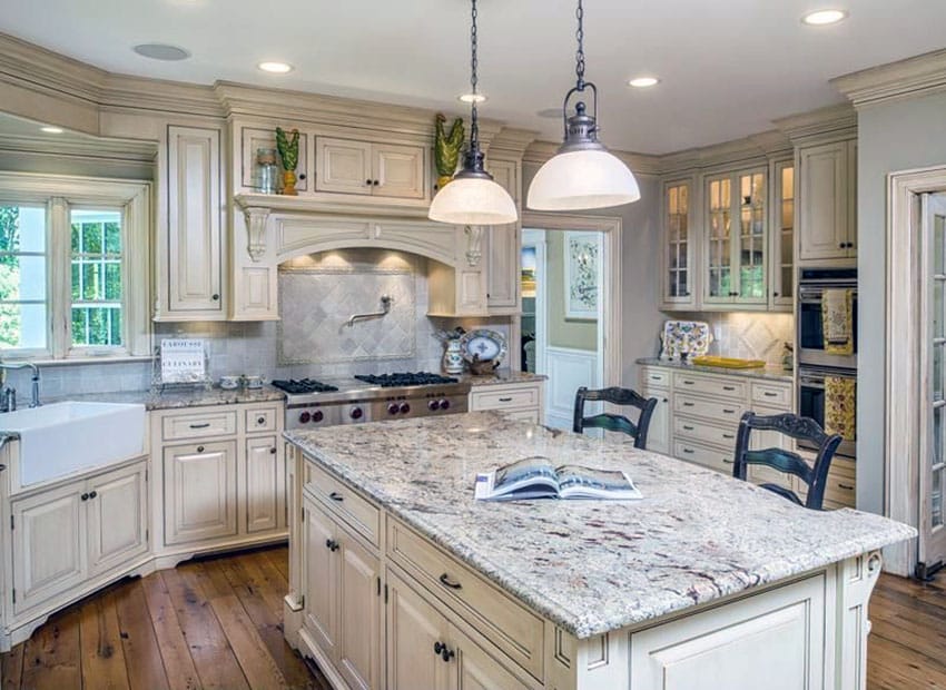 Kitchen with off white tone cabinets, bianco antico granite and apron sink